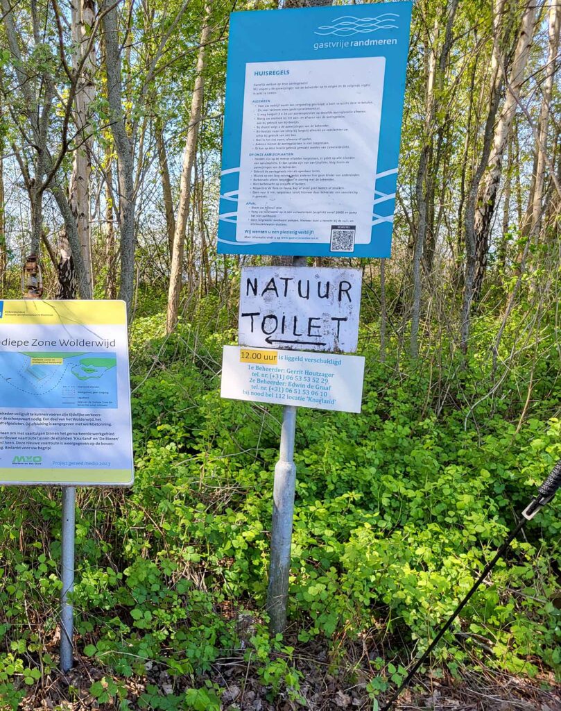 Maritimes Erbe erleben: Eine traditionelle Botterfahrt auf dem Veluwemeer ab Harderwijk 12 : Informationstafel zum Naturgebiet Wolderwijd und einem Schild mit der Aufschrift „Natuur Toilet“.