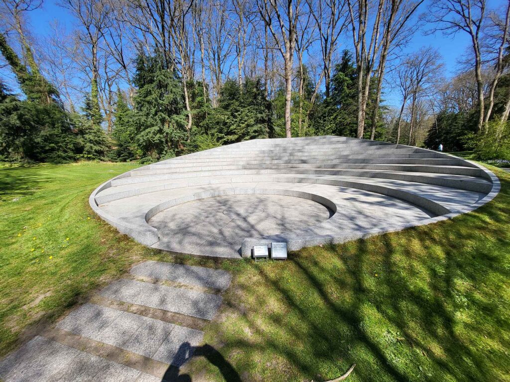 Kreisförmige, stufenartige Steininstallation im Park, die wie ein kleines Freiluft-Amphitheater wirkt