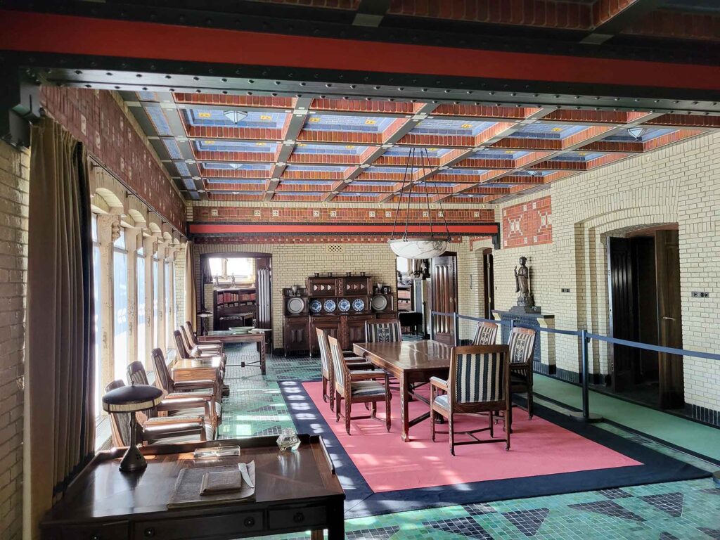 Großer Speisesaal mit Holzmöbeln, langer Tafel und dekorativer Decke im Jagdhaus St. Hubertus