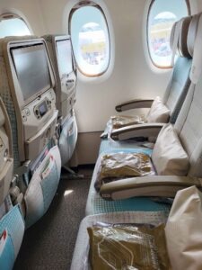 Fensterplätze im Emirates Airbus A380 mit Sitzreihe 84, Kissen, Decken und großen Flugzeugfenstern.