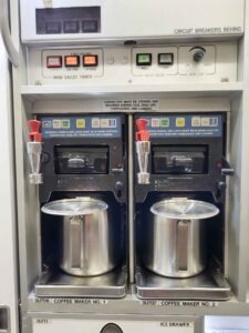 Zwei Kaffeemaschinen in der Galley eines Emirates Airbus A380 mit Bedienfeldern und Metallkannen.