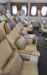 Premium-Economy-Kabine im Emirates Airbus A380 mit hellen Sitzen, Kissen und großen Fenstern.
