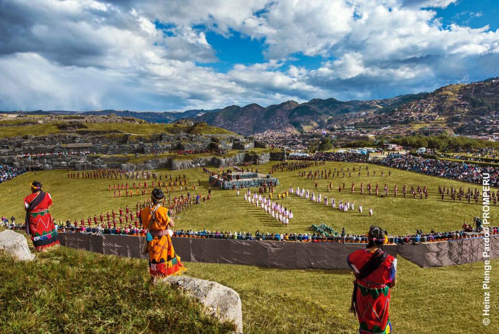 Große Inti-Raymi-Aufführung in Saqsaywaman mit vielen Darstellern und Zuschauern vor den Bergen von Cusco.