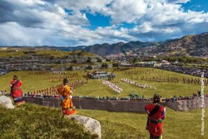 Große Inti-Raymi-Aufführung in Saqsaywaman mit vielen Darstellern und Zuschauern vor den Bergen von Cusco.