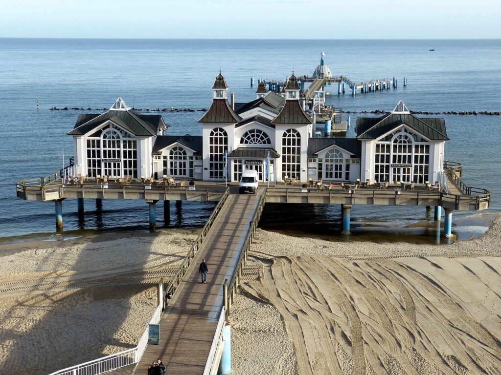 Rügen entdecken: Deutschlands größte Insel zwischen Ostseecharme und Naturwundern 4 Seebrücke Sellin auf Rügen mit Pavillons, Holzsteg, Sandstrand und ruhiger Ostsee.