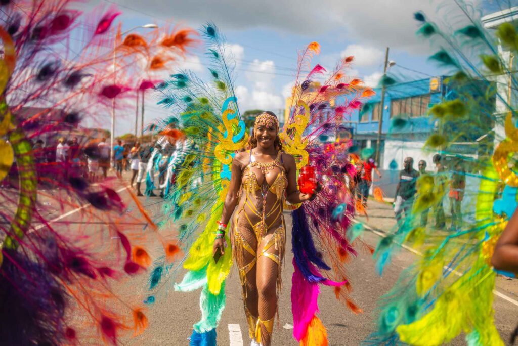 Teilnehmerin des Lucian Carnival in einem bunten Federkostüm während der Parade of the Bands auf Saint Lucia.