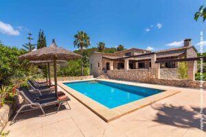 Natursteinfinca Es Garrovers auf Mallorca mit privatem Pool, Sonnenliegen und Schilfsonnenschirmen