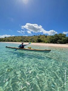 Indonesien: Und dann steht der Komodowaran vor mir 4 Thomas Bauer in einem Seekajak auf glasklarem Wasser vor einem hellen Sandstrand und grünen Hügeln