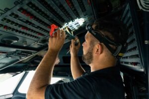 Sitzplatzangebot und Service in den Lufthansa-Maschinen 59 Techniker führt Arbeiten an der Elektronik im Cockpit eines Lufthansa-Flugzeugs für die Starlink-Installation durch.