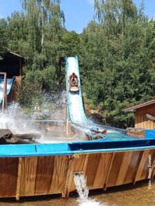 Ein Sommertag im Bayern-Park: Wasserspaß, Achterbahnen und Geduld beim Anstehen 17 Baumstammboot auf der steilen Abfahrt der Wildwasserbahn im Bayern-Park