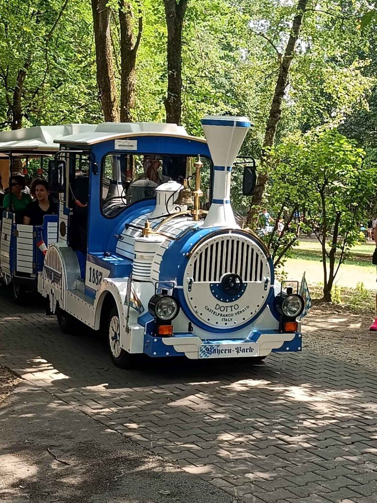 Ein Sommertag im Bayern-Park: Wasserspaß, Achterbahnen und Geduld beim Anstehen 10 Blau-weiße Parkbahn im schattigen Waldgebiet des Bayern-Parks