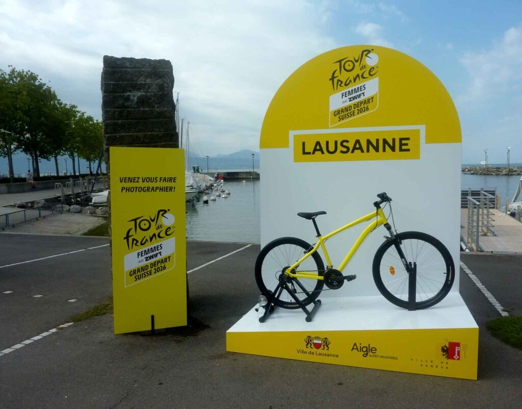 Radsport, Hitze und Erbauung 5 Gelbe Tour-de-France-Femmes-Fotokulisse mit Fahrrad am Place de la Navigation in Lausanne.