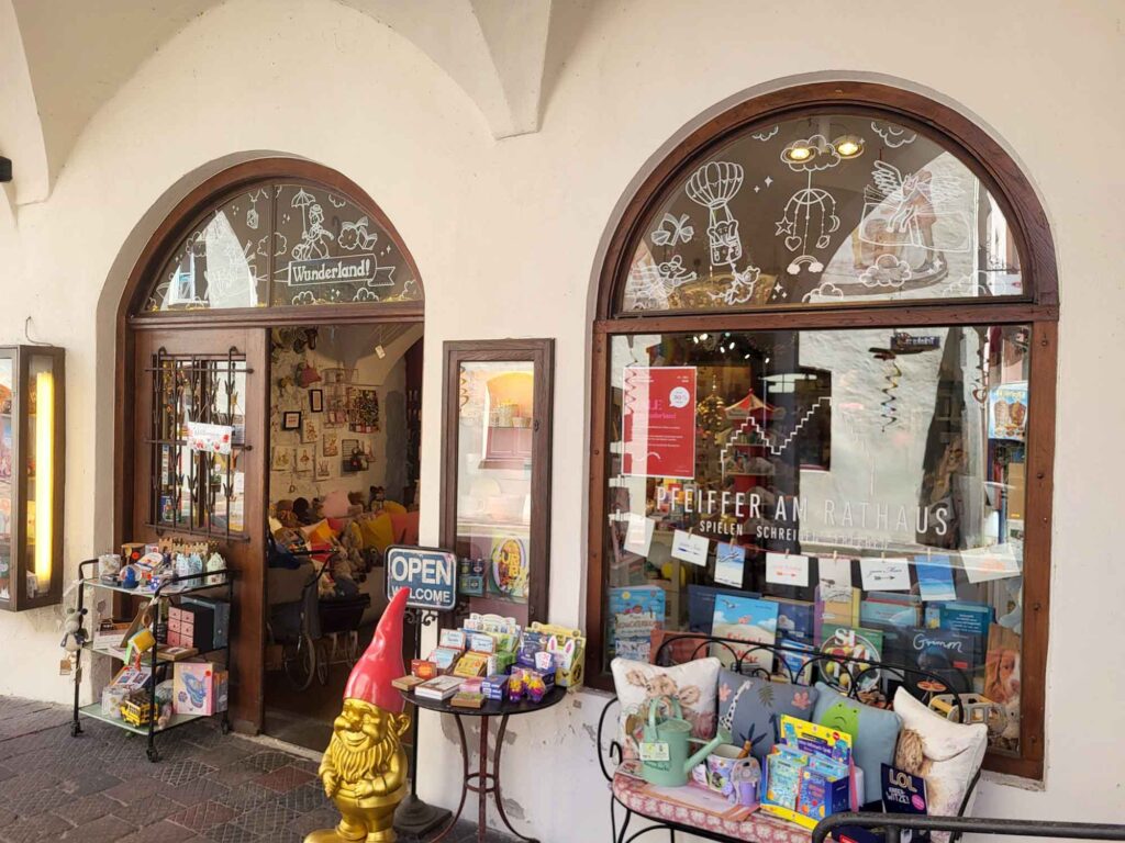 Wasserburg am Inn: Bayerische Bilderbuchstadt in der Innschleife 9 Schaufenster und Eingang von Pfeiffer am Rathaus in Wasserburg, davor Spielwaren, Kissen und ein goldener Gartenzwerg.
