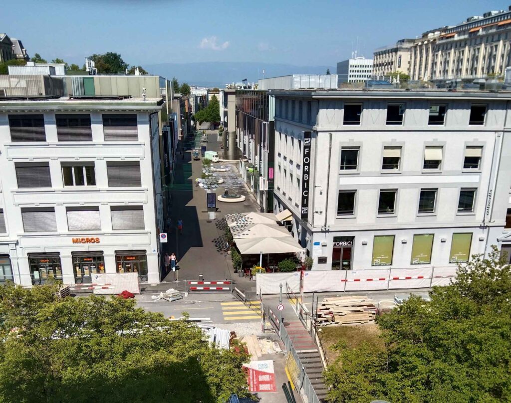 Radsport, Hitze und Erbauung 17 Blick über das dicht bebaute Quartier du Flon in Lausanne mit Straßen, Gebäuden, Baustelle und wenigen Grünflächen.
