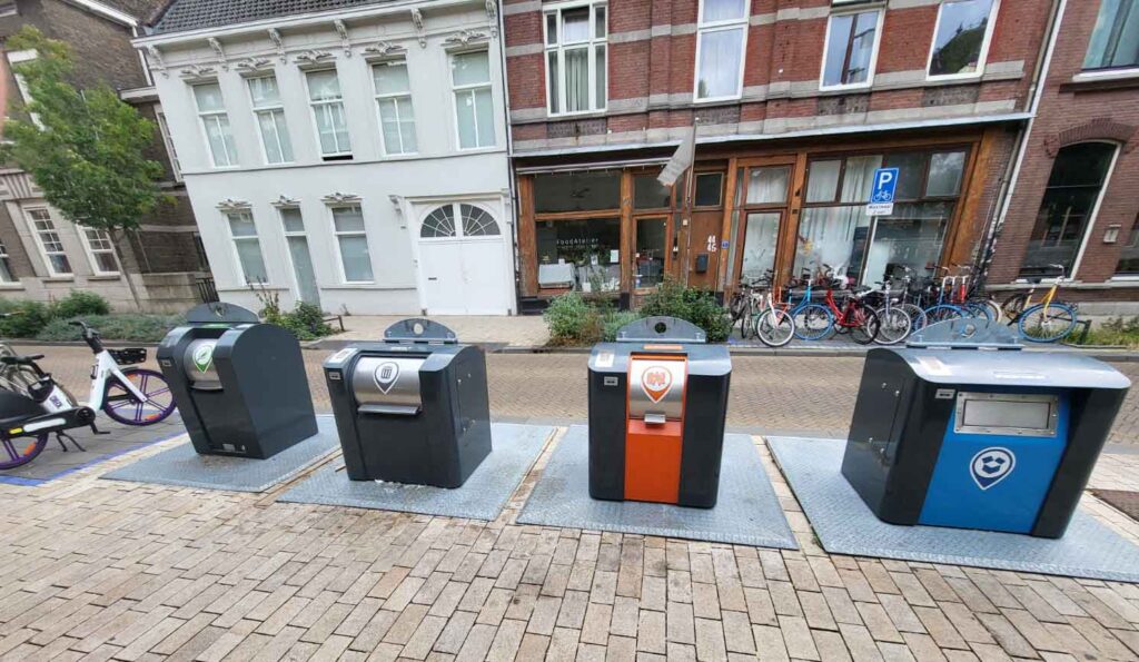 Tilburg: Wo Industriekultur auf Design und neue Ideen trifft 37 Vier Abfallcontainer für unterschiedliche Müllarten auf einer Straße in Tilburg.
