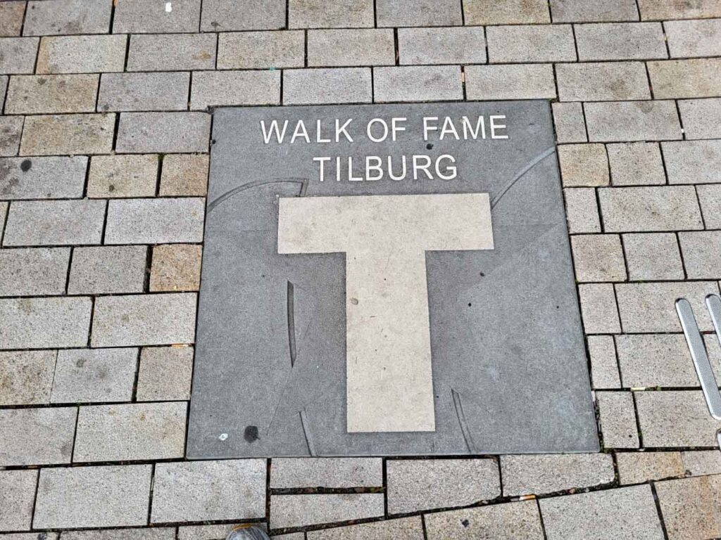 Tilburg: Wo Industriekultur auf Design und neue Ideen trifft 21 Graue Bodenplatte mit der Aufschrift „Walk of Fame Tilburg“ und einem weißen Stern.