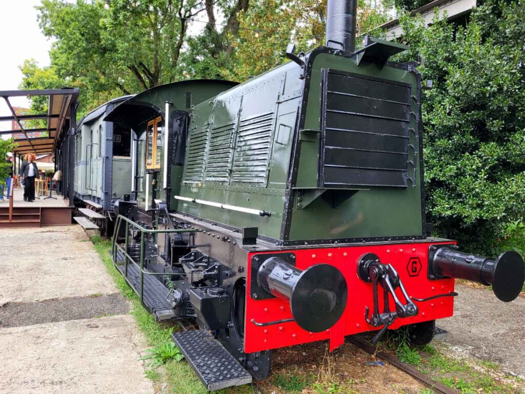Tilburg: Wo Industriekultur auf Design und neue Ideen trifft 10 Historische grün-schwarze Rangierlokomotive mit roter Pufferbohle vor der Eetbar De Wagon in Tilburg.