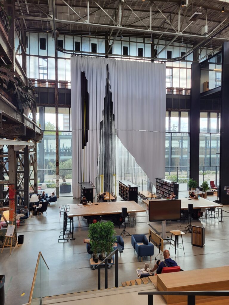Tilburg: Wo Industriekultur auf Design und neue Ideen trifft 15 Hohe weiße und transparente textile Vorhänge im offenen Innenraum der LocHal in Tilburg.