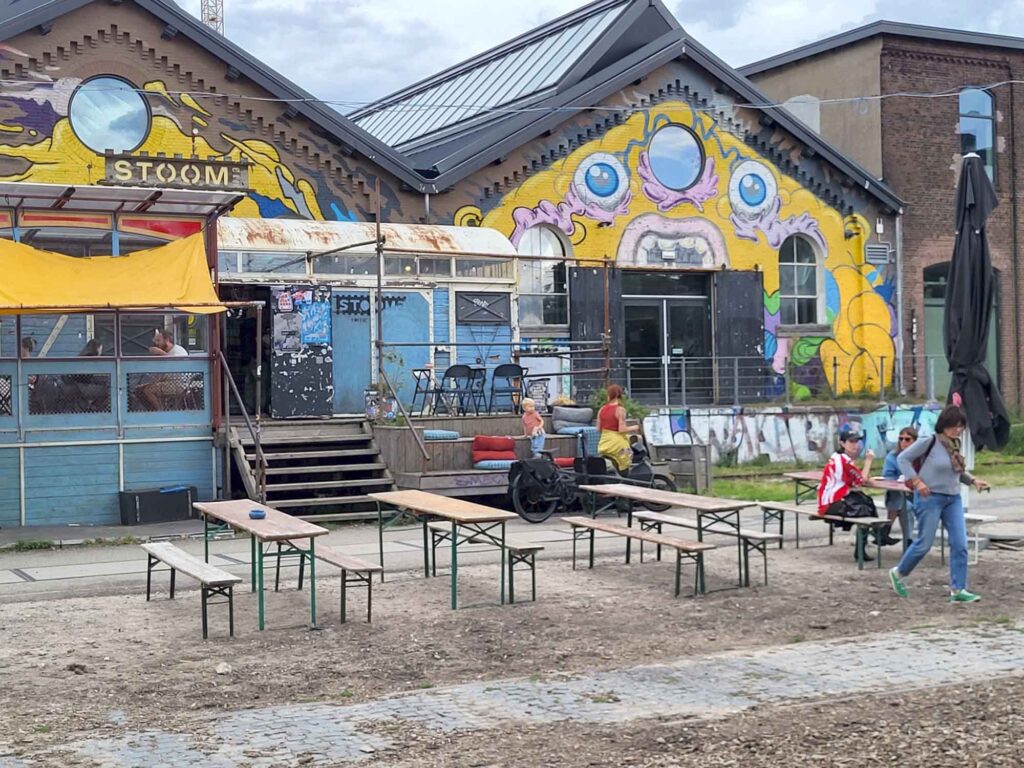 Tilburg: Wo Industriekultur auf Design und neue Ideen trifft 20 Mit großflächiger Street-Art bemalte Backsteinhalle von STOOM013 in der Spoorzone von Tilburg.