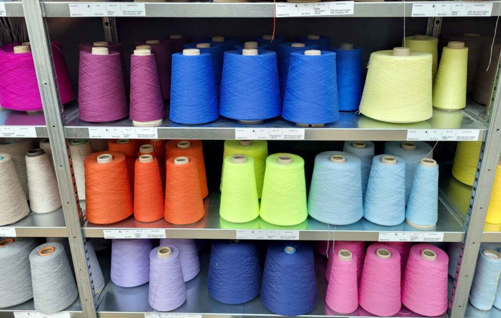 Tilburg: Wo Industriekultur auf Design und neue Ideen trifft 29 Regal mit Garnrollen in Blau, Pink, Orange, Gelb und weiteren Farben im TextielLab Tilburg.