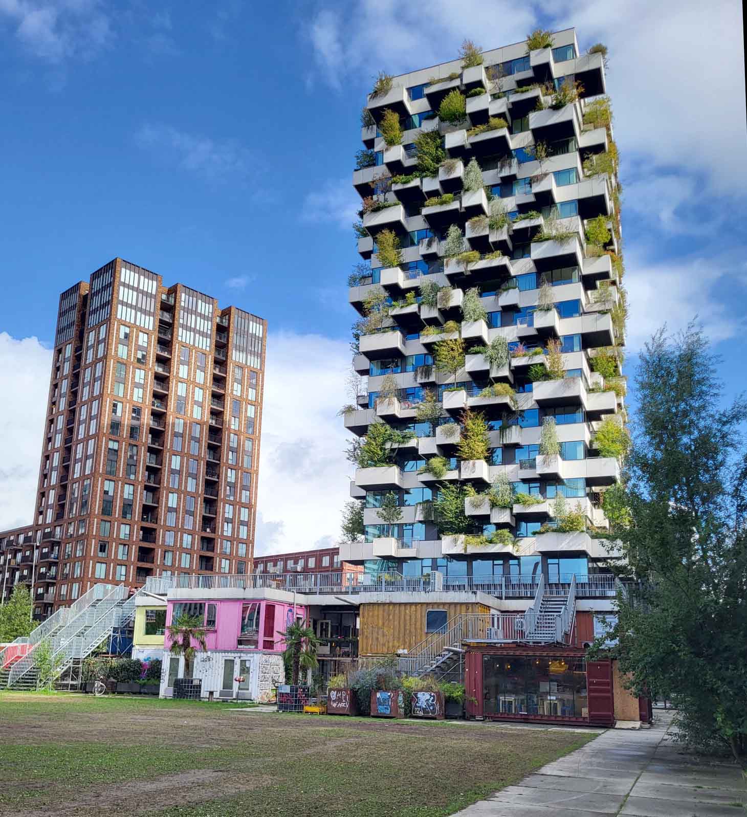 Eindhoven: Vom Philips-Erbe zur Zukunftsstadt 1 Begrünte Trudo Toren auf Strijp-S mit auskragenden Balkonen und Bäumen vor blauem Himmel.