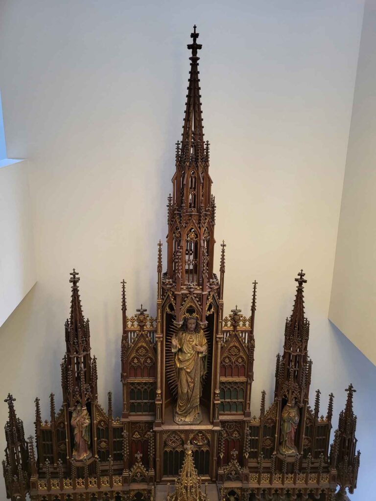 Eindhoven: Vom Philips-Erbe zur Zukunftsstadt 22 Reich verzierter neugotischer Hochaltar aus dunklem Holz mit Figuren und hohem Mittelturm.