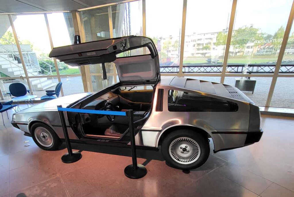 Eindhoven: Vom Philips-Erbe zur Zukunftsstadt 33 Silberner DeLorean DMC-12 mit geöffneter Flügeltür in einer Ausstellung im Evoluon in Eindhoven.