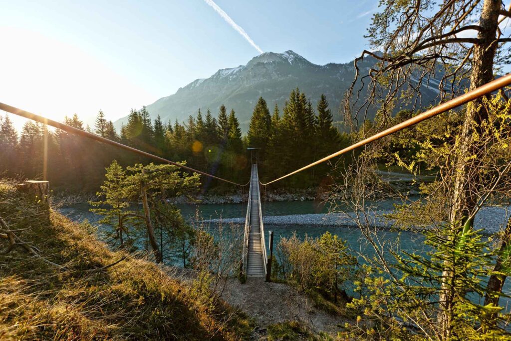 Auf den Spuren des Malers Max Kuhn: Das Lechtal rund 160 Jahre später 15 Schmale Hängebrücke über den Lech bei Forchach vor bewaldeten Bergen