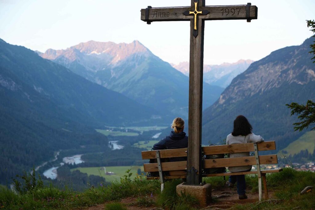 Auf den Spuren des Malers Max Kuhn: Das Lechtal rund 160 Jahre später 16 Zwei Menschen auf einer Bank am Baichlstein mit Blick auf den Lech und die umliegenden Berge