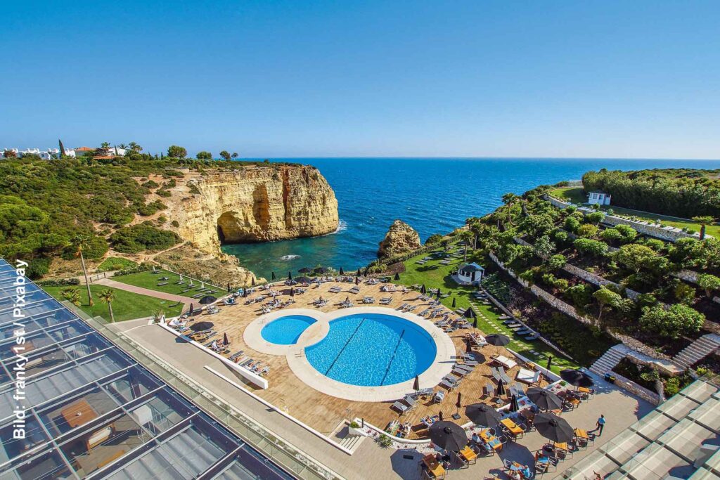 Portugal: Rabatte für Langzeit-Urlauber in den Vila Galé-Hotels 5 Zwei Swimmingpools einer Hotelanlage vor einer Felsbucht und dem blauen Atlantik an der Algarve in Portugal